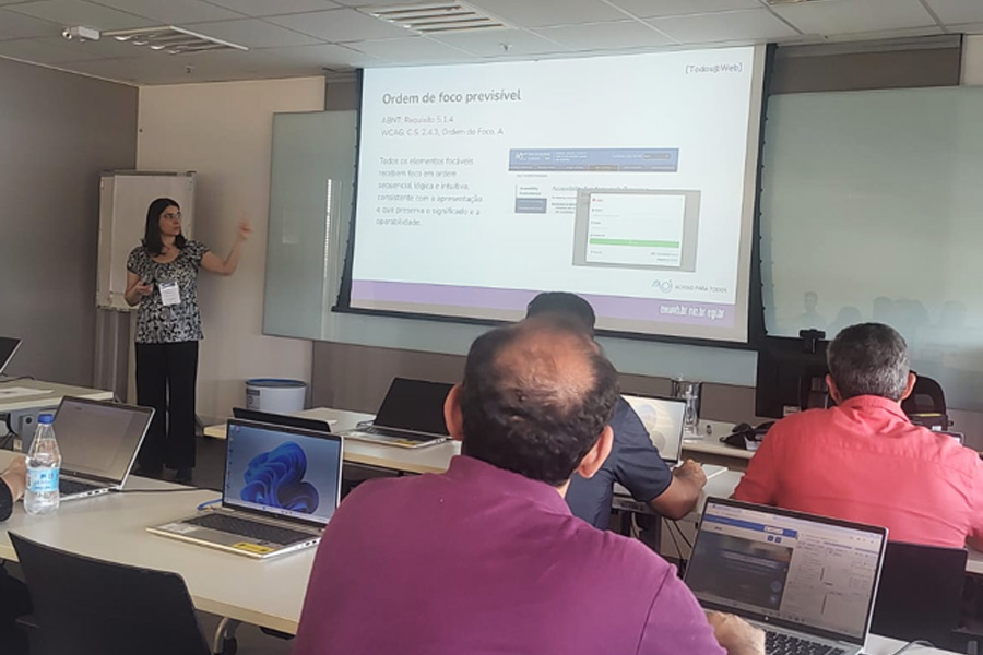 Cláudia Nascimento ministra treinamento para servidores do governo. Na tela, informações sobre ordem do foco previsível.