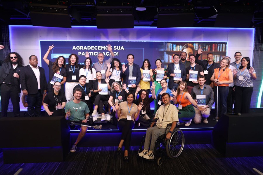 Equipe de palestrantes e apresentadores segurando a publicação impressa da norma ABNT NBR 17225 no palco do evento de lançamento.