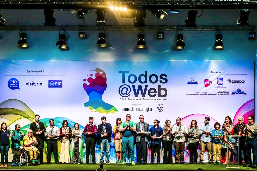 Foto com todos os premiados segurando troféus e equipe do W3C Brasil.